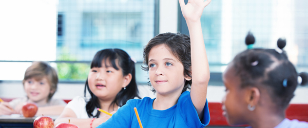 Multiracial classroom primary school. Kid raising his hand ready